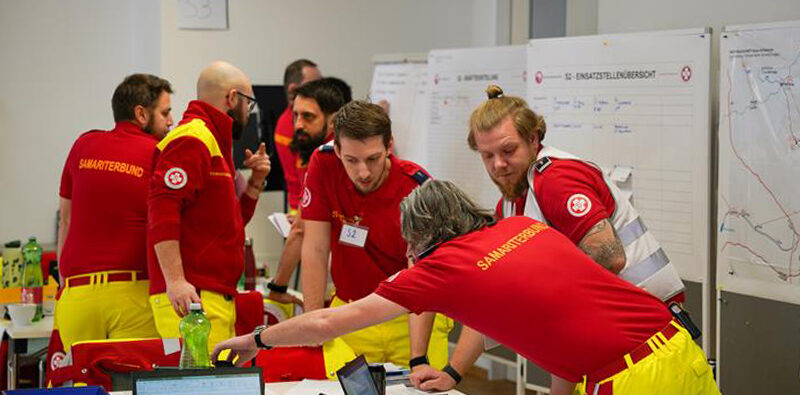 Krisenmanagement Einsatzleiter und Mitarbeiter:innen des Krisenstabs bei der Planung